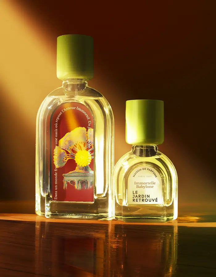 Immortelle Babylone 15 et 50 ml sur une table avec un rayon de soleil, le fond est marron